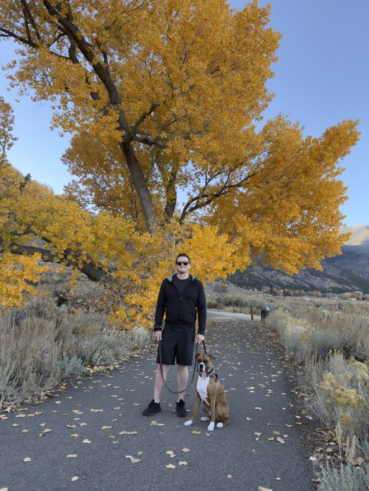 Scott Reilly with his dog under cottonwood trees in Douglas County, Nevada